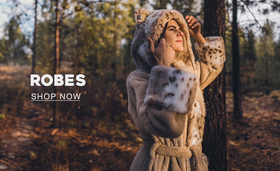 Woman wearing a faux fur bath robe with text at the bottom that says ROBES Shop Now