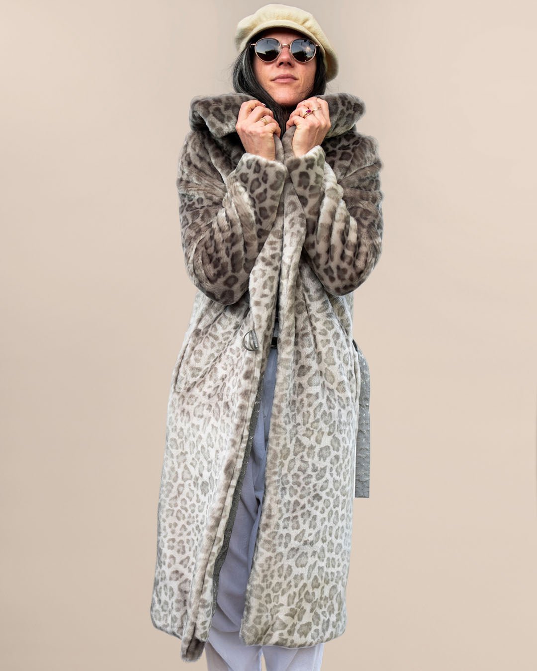 Girl in sunglasses and beret holding lapels up, flaunting the Silver Leopard Classic Wrap Faux Fur Long Jacket with an unbelted waist.