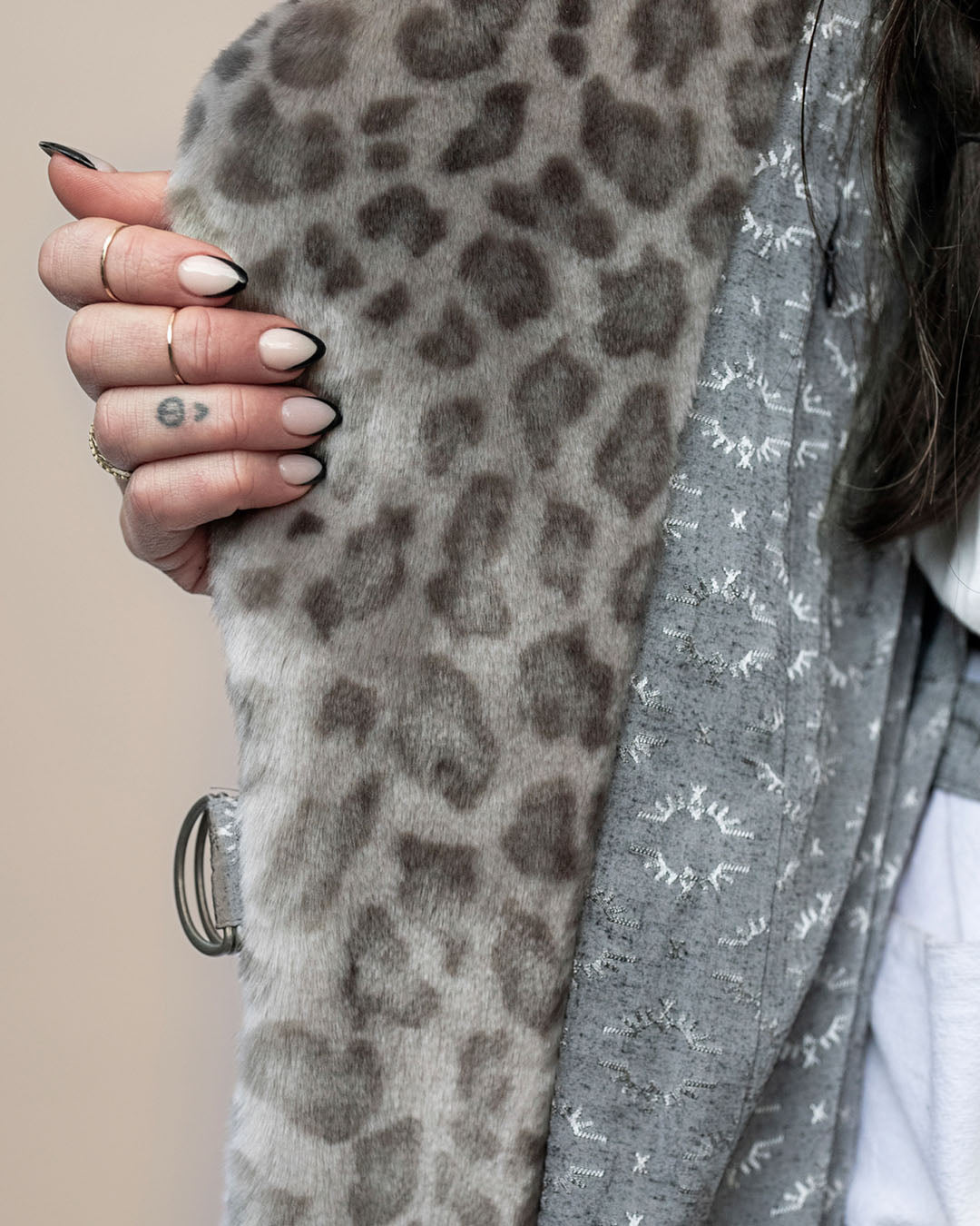 Close-up of the Silver Leopard Classic Wrap Coat, showcasing the faux fur liner and belt loop with a model's manicured nails.