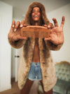 Hooded African Golden Cat Luxe Faux Fur Coat on Model Holding SpiritHood Logo Comb