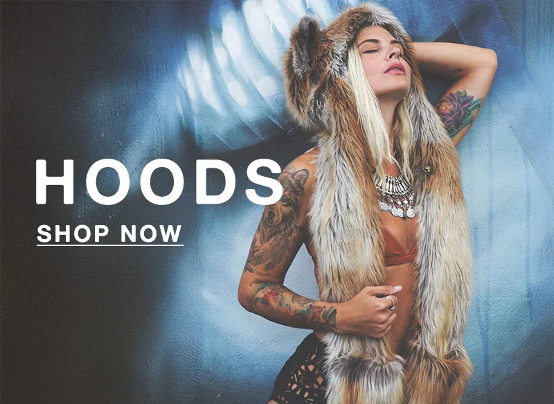 BLONDE WOAMN WITH TATTOOS WEARING A RED FOX ORIGINAL FAUX FUR SPIRITHOOD STANDING AGAINST A BLUE WALL