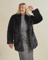 Curvy blonde gal smiling with her hand up touching her hair wearing a realistic collard black panther fur coat. 