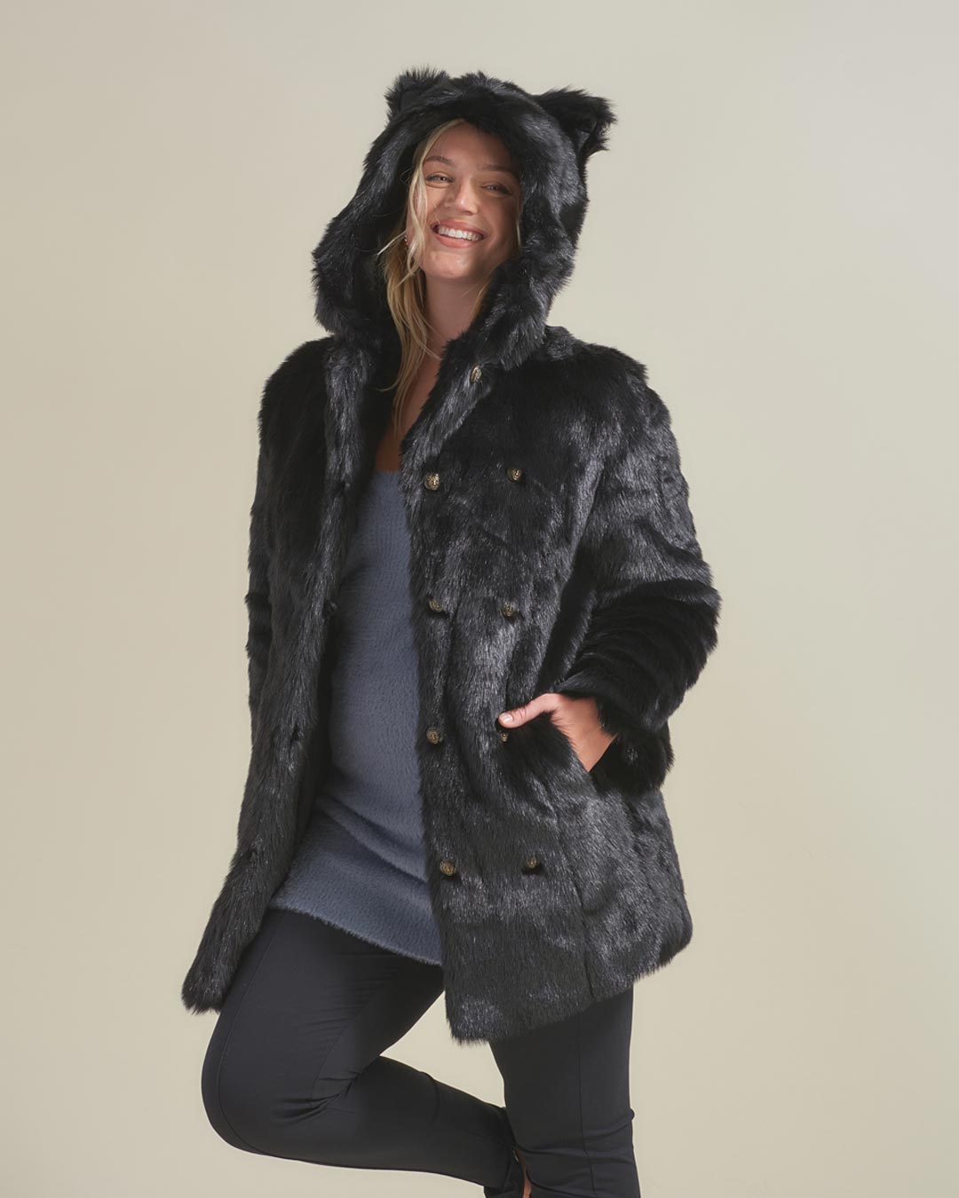 Blonde curvy lady smiling with her hand in the pocket of a fake fur hooded with ears Black Panther Jacket.