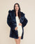 Dark-haired girl in Classic Indigo Leopard vegan fur coat with hood and ears. Hand on waist, striking pose.