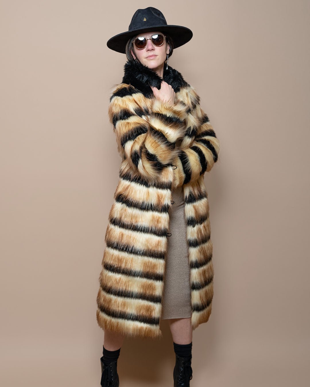 Girl in black fedora and sunglasses, arms crossed, holding the collar of the Gazelle Collared Long Faux Fur Jacket.