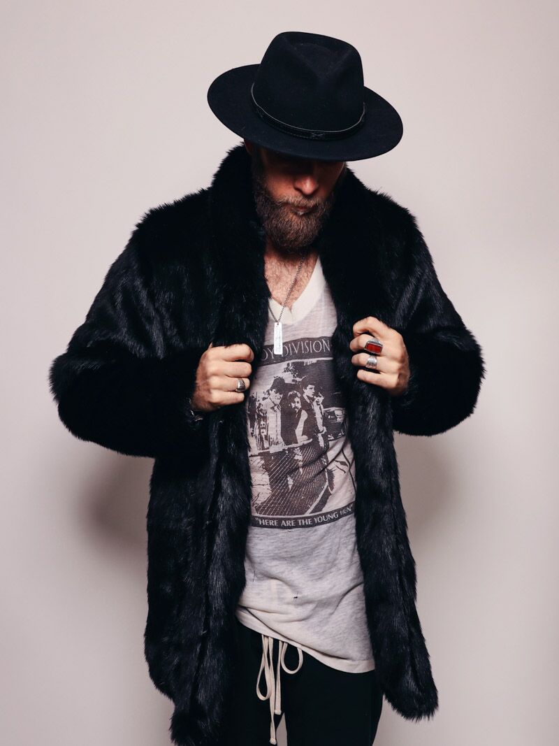 Guy in a fedora with his head down holding the lapels of a realistic black panther fur coat. 