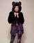 Blonde female model wearing midnight wolf dark purple faux fur coat with hood and ears holding the neck with both hands and staring into camera with slight smile on her face. 