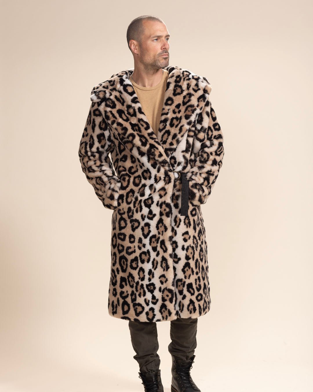 Handsome male model with hood and ears down, looking to the side, belt closed, hand in pocket of Classic Men's Long Fake Fur Jacket in Arabian Leopard Print.