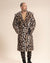 Handsome male model with hood and ears down, looking to the side, belt closed, hand in pocket of Classic Men's Long Fake Fur Jacket in Arabian Leopard Print.