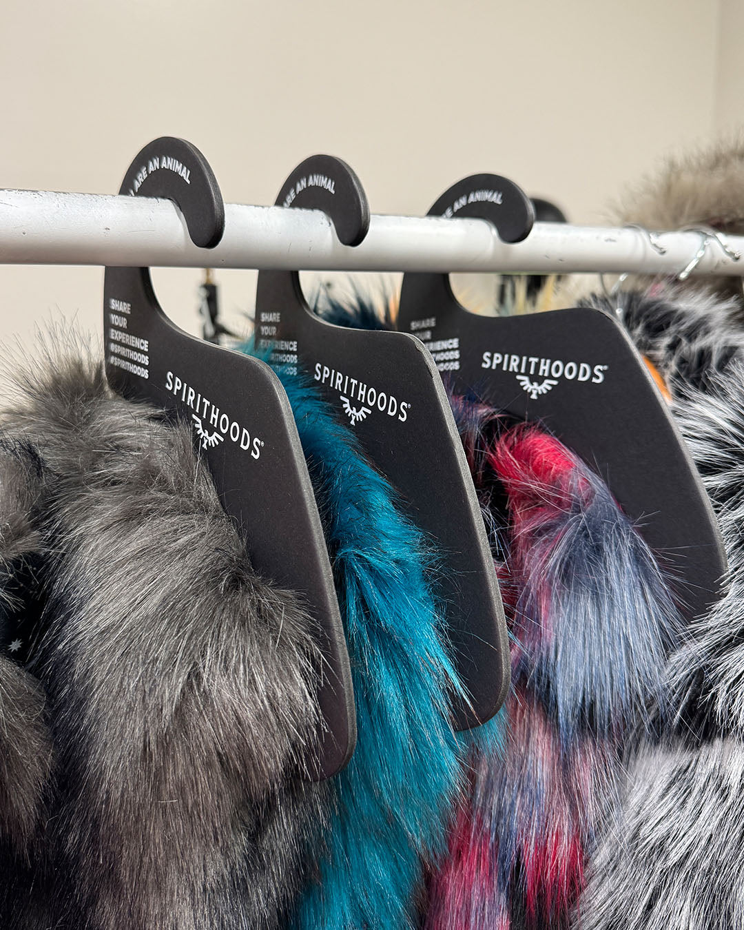 Cardboard hangers with faux fur clothing hanging on a rack