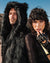 Couple facing the camera with the male model wearing realistic fake fur black wolf coat with hood and ears.