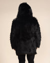 A guy is wearing a black wolf faux fur coat, facing away from the camera with his arms at his sides.