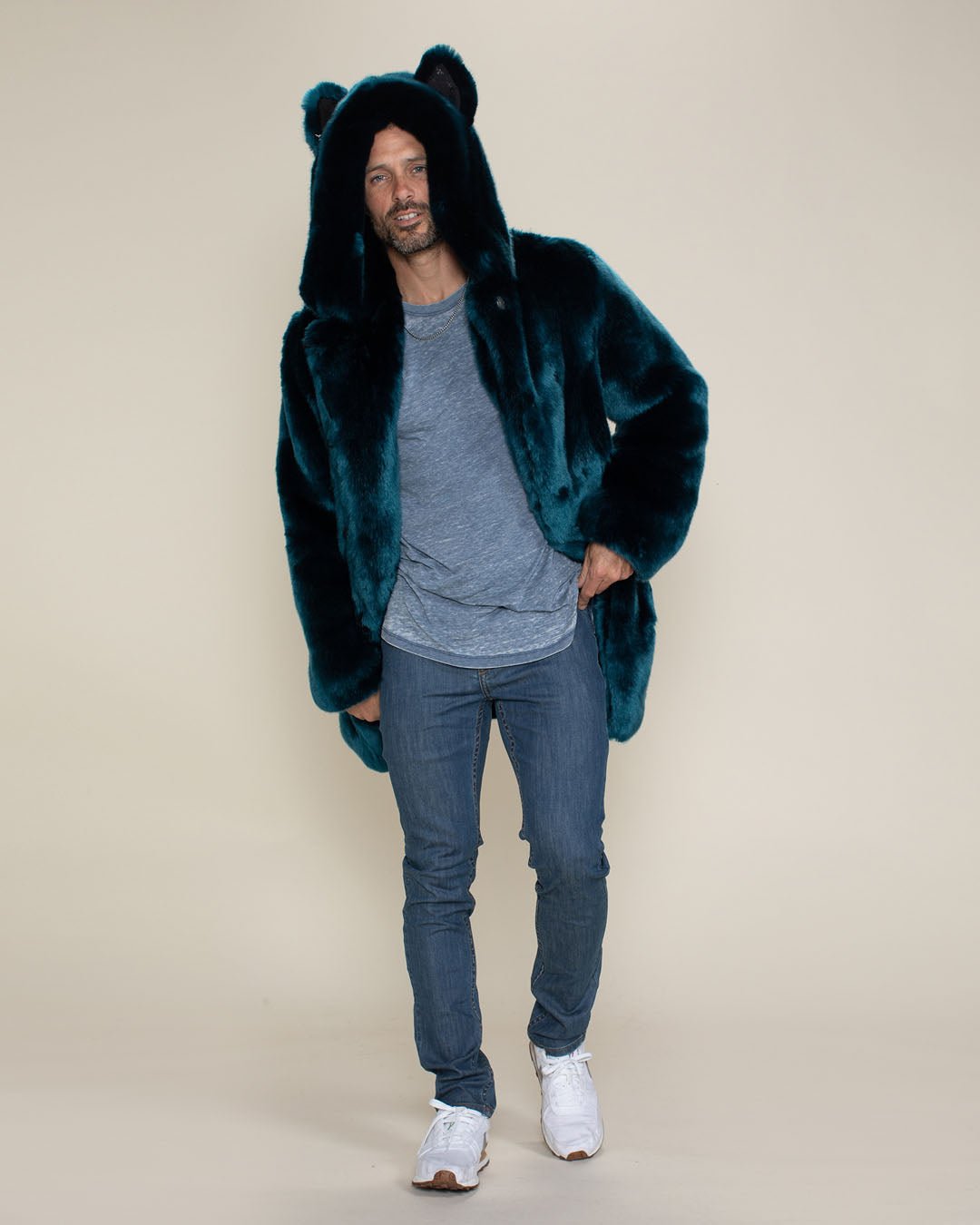 Coy-faced man wearing the Royal Wolf faux fur coat takes a step forward with one hand in his pocket.