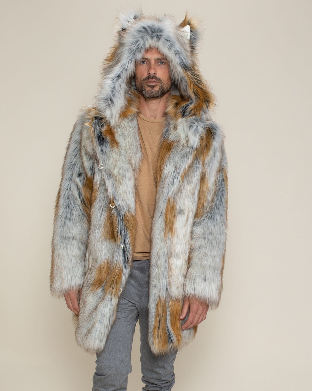 A guy with his hands at his sides, wearing a faux fur jacket called the Classic Arctic Fox, with the hood and ears up.