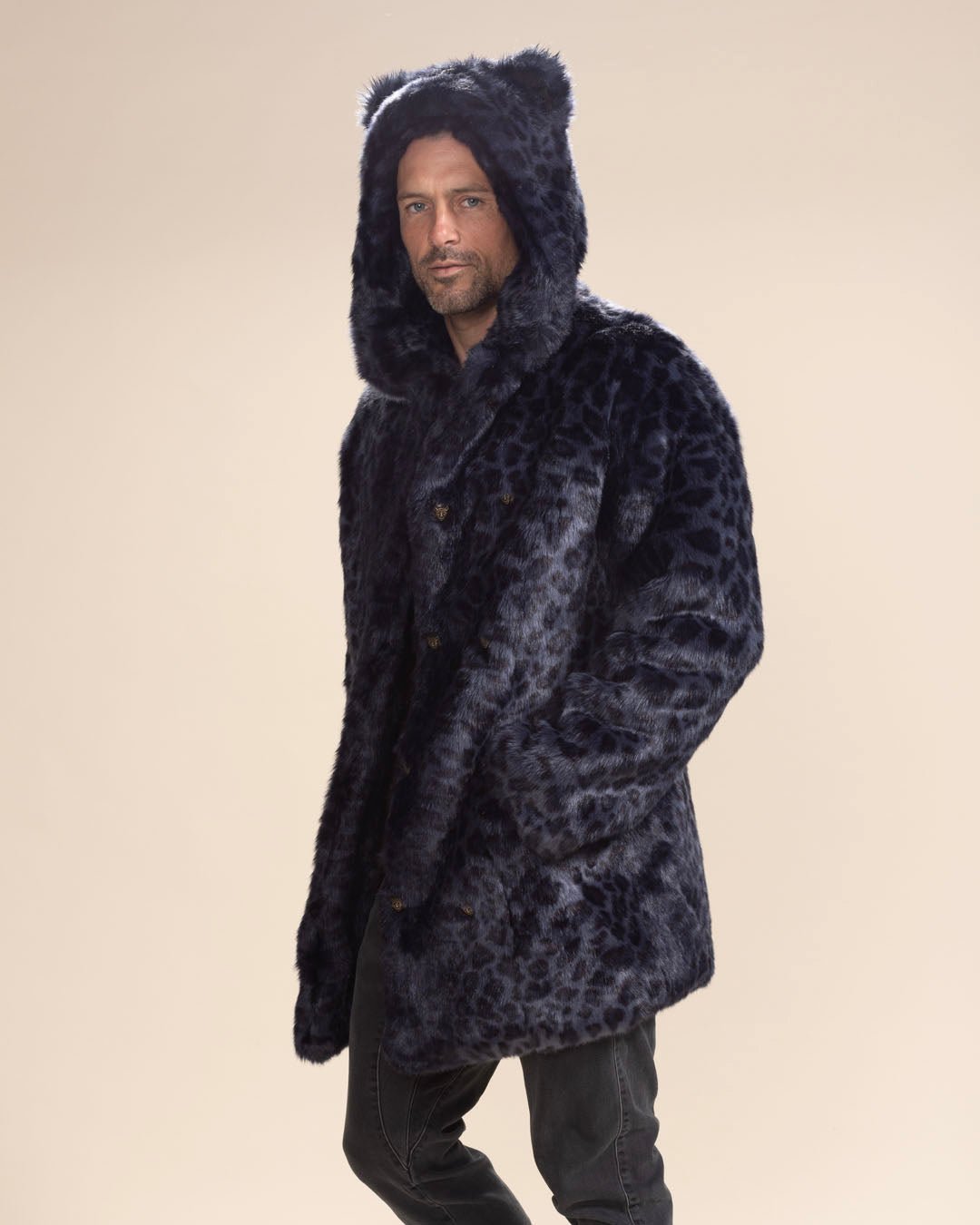 Handsome guy smirking at the camera, wearing the buttoned Indigo Leopard Collector Edition Vegan Fur Coat with hood and ears up, knee bent as if walking away.