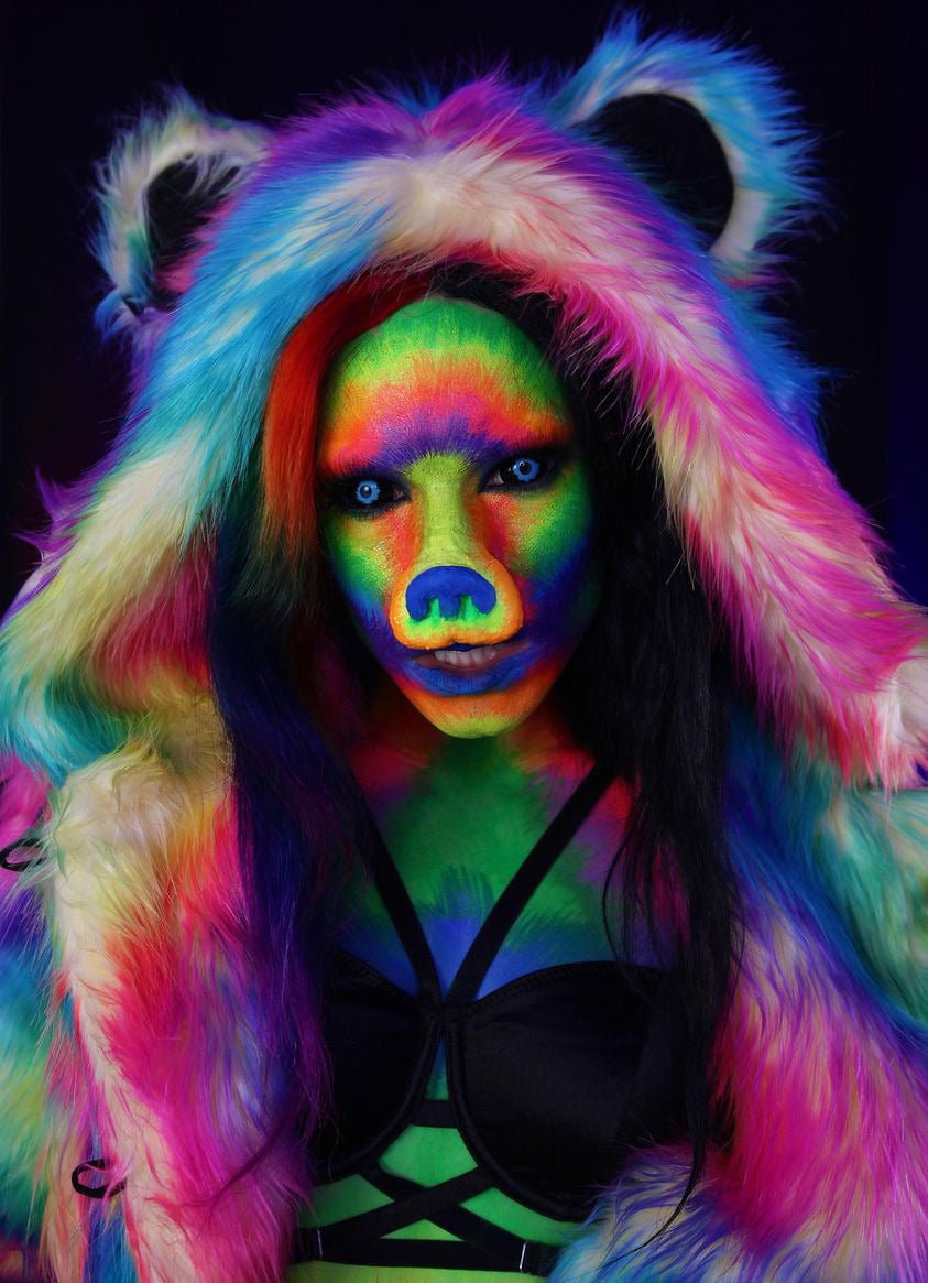 Girl with spooky rainbow bear face paint, wearing Rainbow Bear Faux Fur Coat with hood and ears for an eerie look.