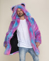 Cute man leaning to one side, holding the right side of his Cotton Candy Bear faux fur coat to showcase the black liner.