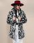 Model in red fedora and sunglasses holding the lapels of the Collared Himalayan Snow Leopard Faux Fur Coat. Chic, stylish look.