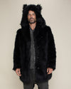 Man model with short beard and mustache wearing fake black wolf fur coat with hood and ears.