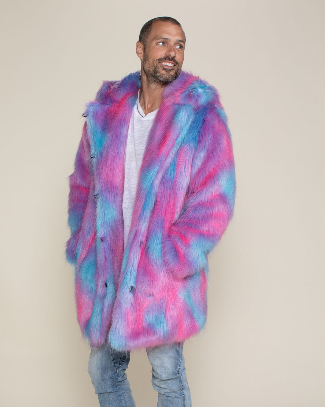 Smiling male model looking to one side in a vegan Cotton Candy Bear fur coat, with his hands in his pockets.