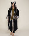 A male model with a small smile and one hand in the pocket of the Grey Wolf faux fur robe.