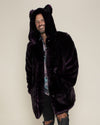 Smiling male model wearing hood and ears with hands in the pockets of Midnight Wolf Dark Purple fake fur jacket.