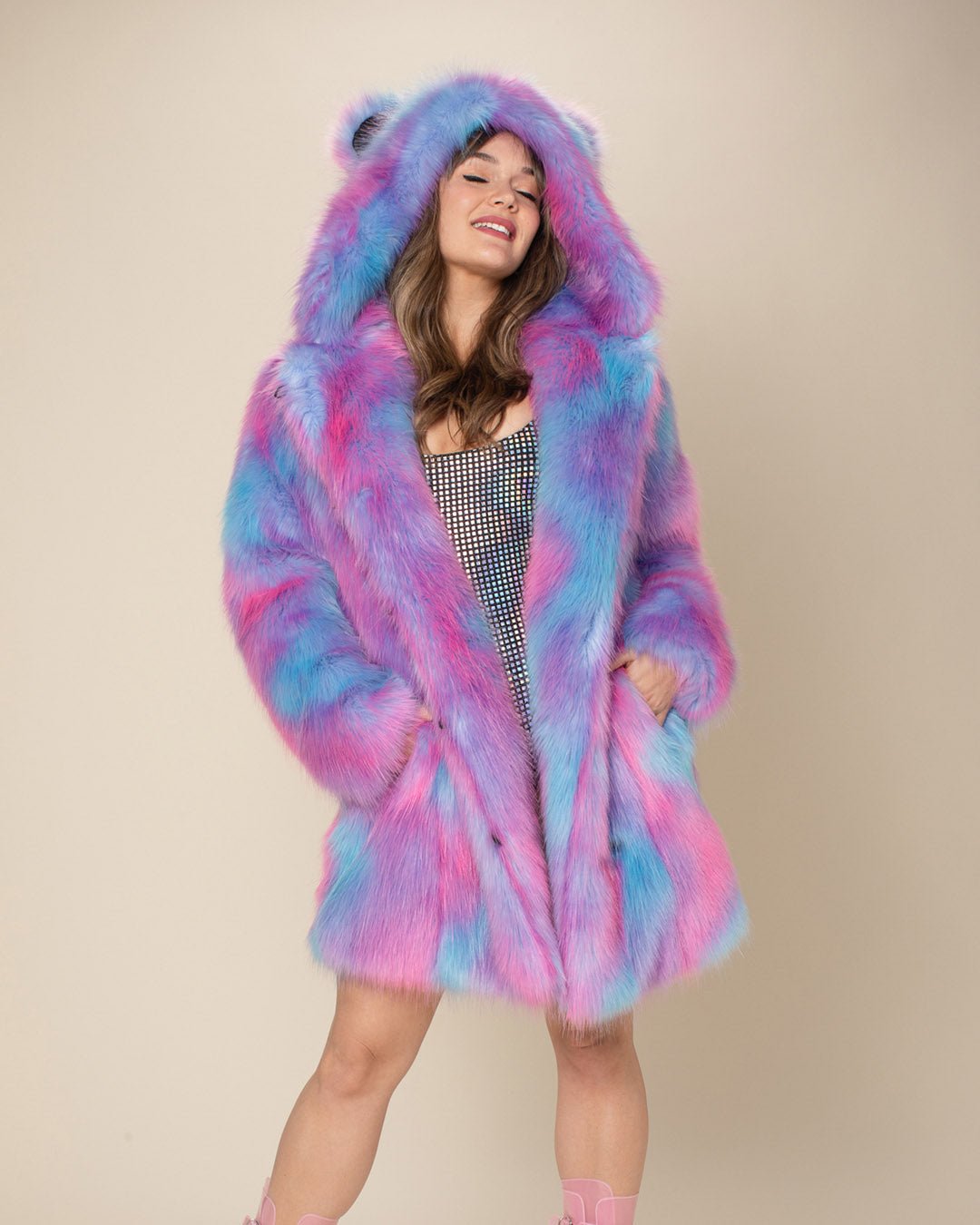 Blissful girl with her head tilted back, hands in pockets of her Cotton Candy Bear faux fur jacket with the hood and ears up.