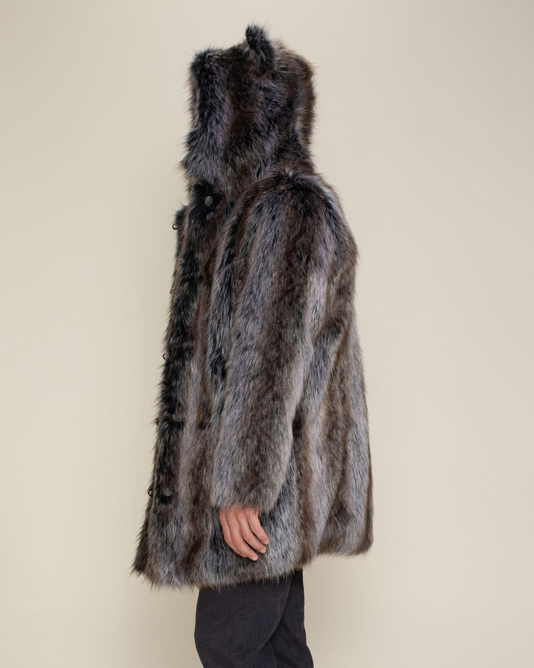 Left side facing man wearing fake fur grey coat with lapel out showing button holes, along with the side view of hood and ears. 