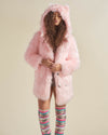 Serious model holds the lapels of her cozy Flamingo Wolf Classic Faux Fur Jacket, showcasing its style and comfort.