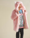 Dude in Flamingo Wolf Classic vegan fur coat holds the lapels, turned slightly to the side, peering into the distance.