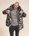 Smiling handsome model, adjusting lapels while putting on the Collared Himalayan Snow Leopard Faux Fur Jacket. Stylish and chic.