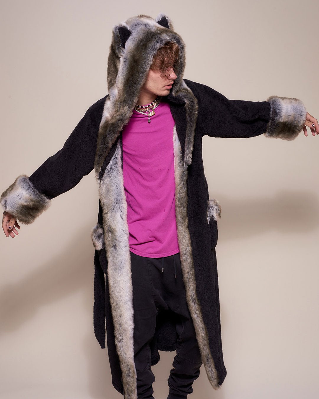 A male model with arms outstretched and head turned to one side, wearing a vegan Grey Wolf robe with a hood and ears.