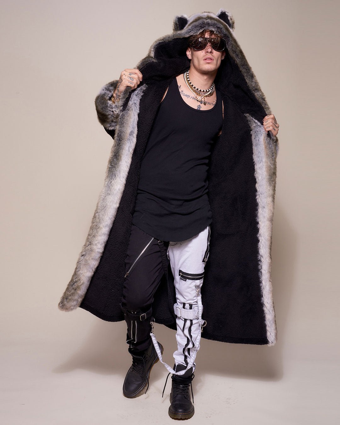 A dude in sunglasses, wearing the Grey Wolf robe with the hood and ears up, holding it open with both hands while taking a step forward.