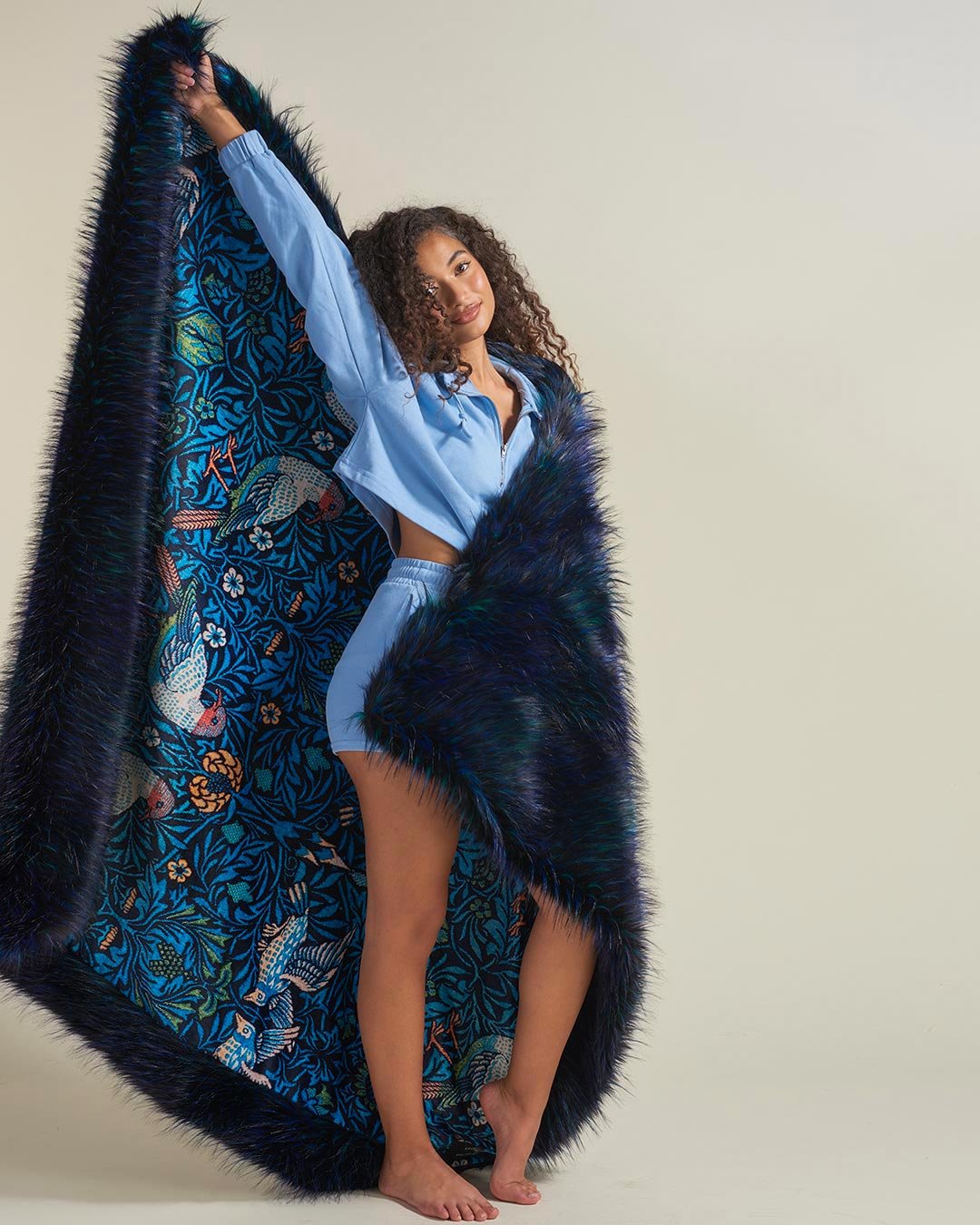 Faux Fur Throw in Nicobar Pigeon Design Held by Female