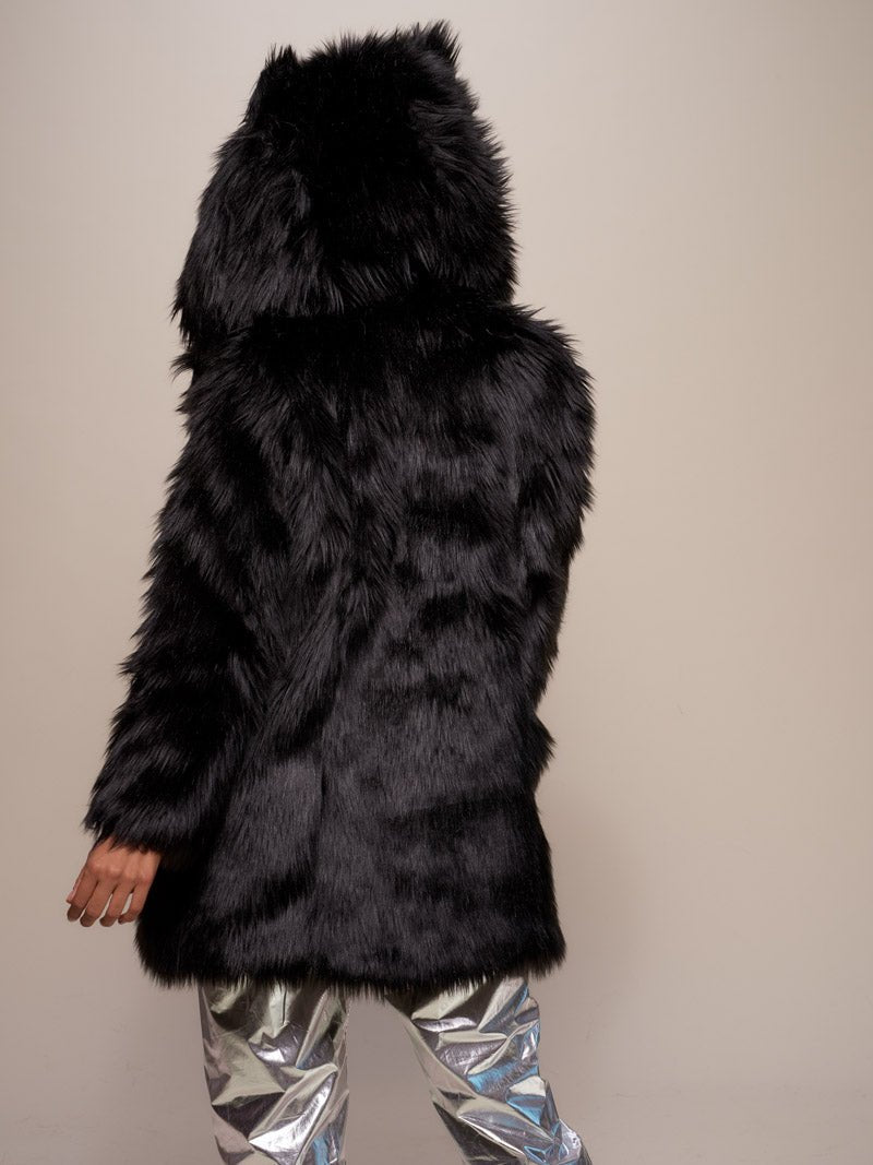 Female model with her entire back to the camera, wearing realistic black wolf coat with hood and ears.