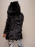 Female model with her entire back to the camera, wearing realistic black wolf coat with hood and ears.