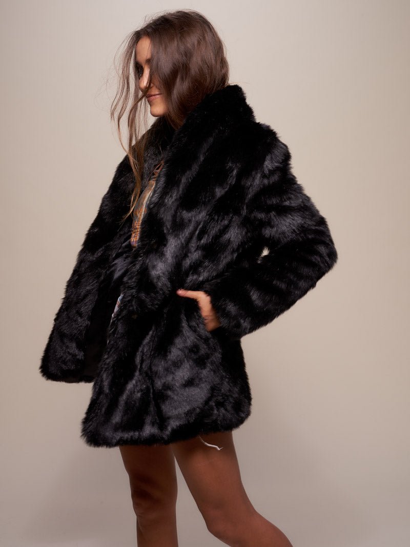 Brown haired gal facing one side with her hand in the pocket of a collard fake fur black panther coat. 