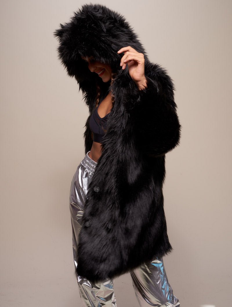 Woman model twisted to one side wearing realist black wolf coat with hood and ears on.