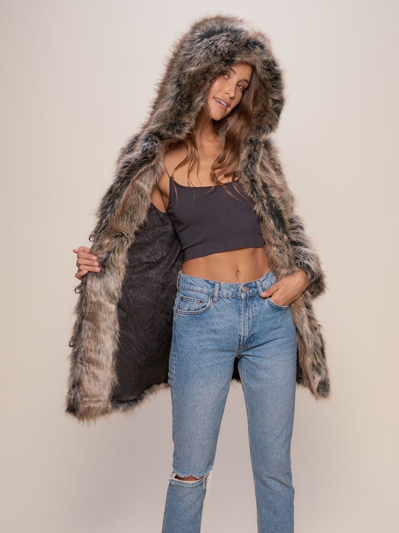 Jean wearing  female model wearing Hooded Grey Wolf fake fur jacket with the hood up while holding it open on one side exposing inner black logo liner.