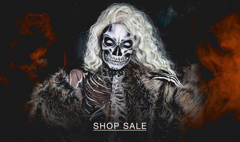 Woman with white hair and skeleton face make up wearing a faux fur grey coat