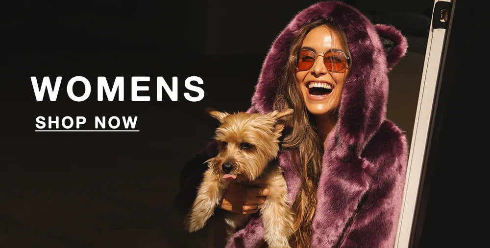 SMILING WOMAN HOLDING A SMALL DOG AND WEARING SUNGLASSES AND A LAVENDER FAUX FUR COAT WITH EARS