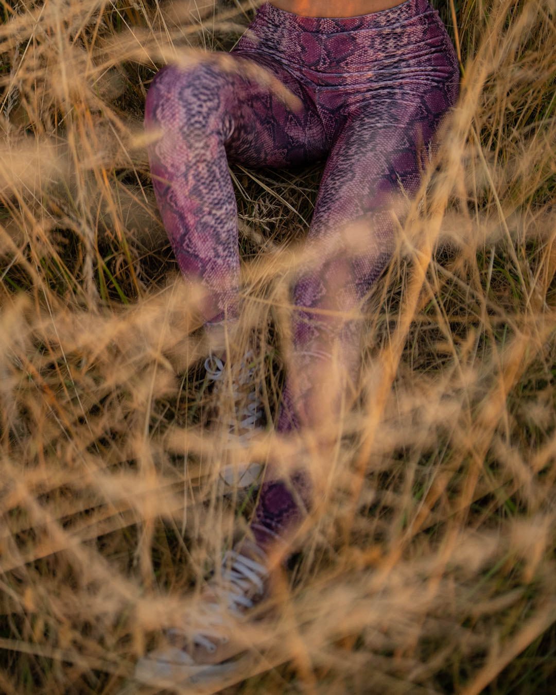 Seated Woman in Pink Python High-Waisted Velvet Leggings